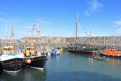 Three contrasting styles of ex-fishing vessels – a herring drifter/seiner, a ringer and a sailing Fifie, in the form of Comrade LK 325, Comet BF 430 and Swan LK 243 – berthed in the outer harbour at Portsoy, alongside the former Macduff lifeboat Douglas Currie.