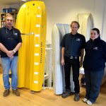 Left to right: general manager Barry Sales, managing director Sean Strevens and office manager Zoe Wilmot Aimes in front of tank testing models of the 9.95m and the new 12m catamaran hulls.