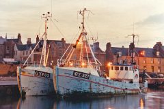 The Danish-built Grimsby pair-trawlers Tino GY 203 and Samantha GY 327 berthed in the south harbour, while their crews repair torn gear on the quay.