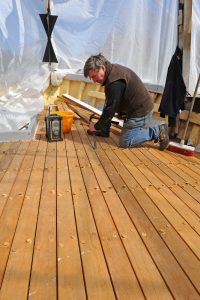 Bobby Cann at work on the new opepe hardwood-planked deck now in place on the Dartmouth crabber Superb-Us.