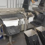 Selected brown crab are cut at a large stainless steel table.