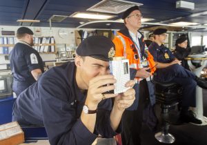 Warfare officer under training SLt Toby Robson using a Stuart’s distance meter to measure the distance to the ship ahead.