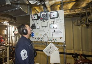 AB (Sea) Iain Barrowman checking the course of HMS Tyne from the secondary steering position.