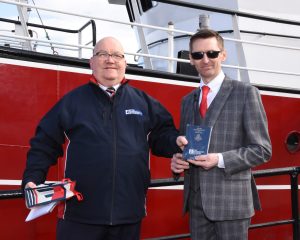 Peterhead Fishermen’s Mission superintendent Steve Murray presents a copy of the New Testament to skipper James West during the naming ceremony of the new twin-rig trawler Westro.