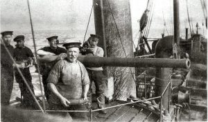A gun crew working on a trawler converted for minesweeping duties.