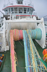 The colour-coded wings of the midwater trawl come off the drum.