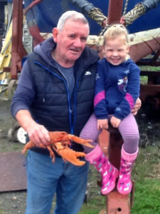 2)Willie MacDonald and his granddaughter hand over the mature orange lobster for release in the same area as the juvenile specimen was returned to the sea.