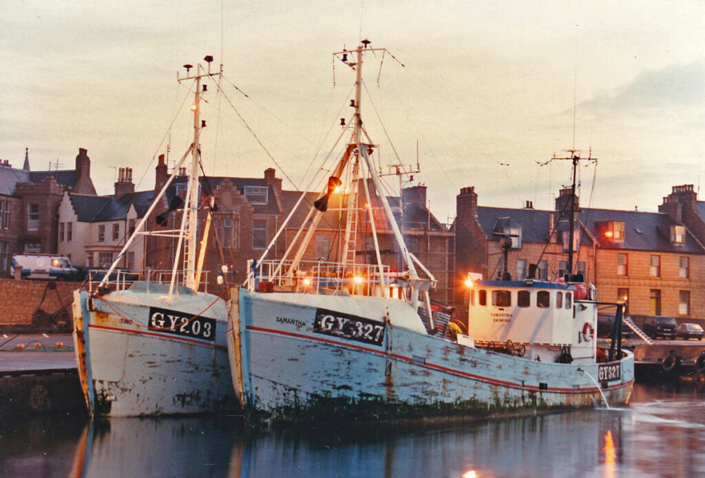 The Danish-built Grimsby pair-trawlers Tino GY 203 and Samantha GY 327 berthed in the south harbour, while their crews repair torn gear on the quay. 